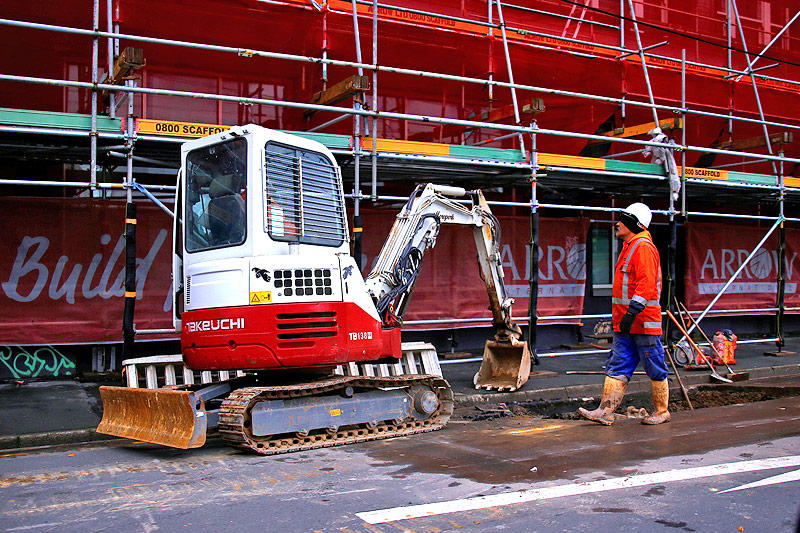 © Reuters/David Gray Arbeiter neben einem Bagger auf einer Baustelle in Wellington (Neuseeland)