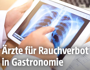 Ein Arzt blickt auf ein R&ouml;ntgenbild der Lunge