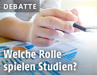 Hand mit Stift &uuml;ber Diagrammen