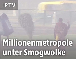 Frau geht durch das durch Smog betroffene Neu Delhi