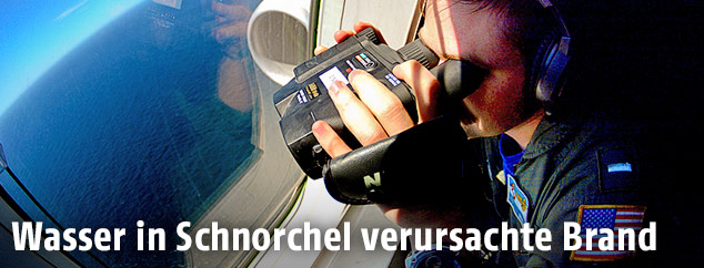Mitglied der US-Navy sucht mit einem Fernglas aus einem Flugzeug das vermisste U-Boot