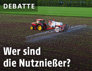 Ein Traktor auf einem Feld sprüht Pestizide