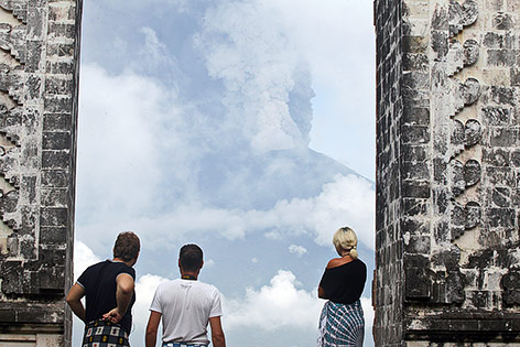 © APA/AP/Firdia Lisnawati Touristen auf Bali beobachten die Rauchsäule des Vulkans Agung