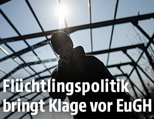 Ein Fl&uuml;chtling in einem heruntergekommenen Fabriksgeb&auml;ude