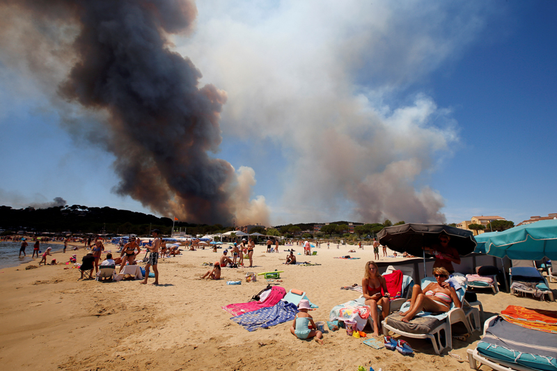 © Reuters/Jean-Paul Strand mit Waldbrand im Hintergrund