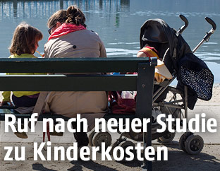 Junge Familie auf einer Parkbank