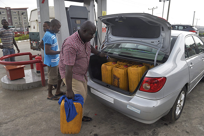 Mann lädt Benzin-Kanister in einen Kofferraum
