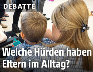 Mutter mit Kindergartenkind auf dem Arm