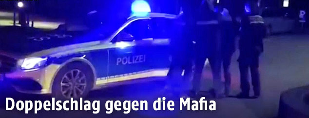 Deutsche Polizisten führen einen Verdächtigen ab