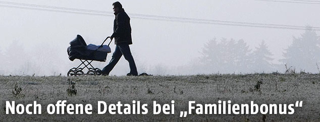 Vater mit Kinderwagen spaziert im Nebel