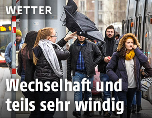Menschen im nasskalten und windigen Wetter
