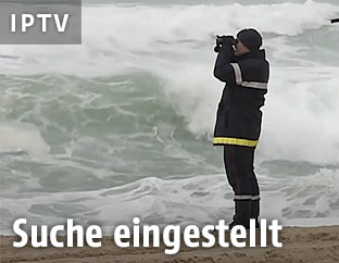 Ein Mann blickt mit einem Fernrohr auf das Meer