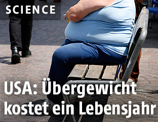 Ein übergewichtiger Mann sitzt auf einer Bank