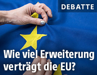 H&auml;nde an einer EU-Flagge