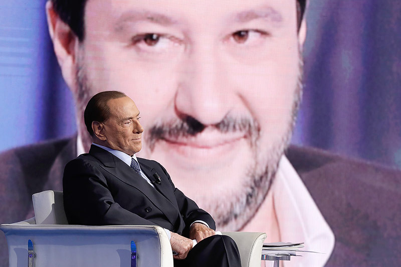 © APA/AP/Andrew Medichini Ex-Premier Silvio Berlusconi, dahinter auf einer TV-Wand Lega-Chef Matteo Salvini