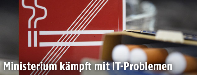 Zigaretten vor einem Rauchverbotschild