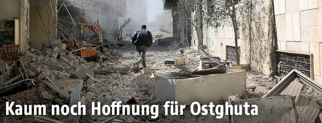 Mann läuft durch eine völlig zerstörte Straße in Ostghuta