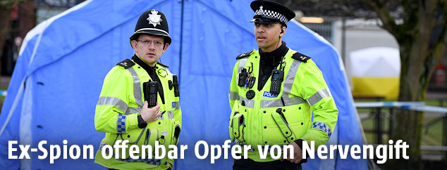 Polizisten vor einem Zelt