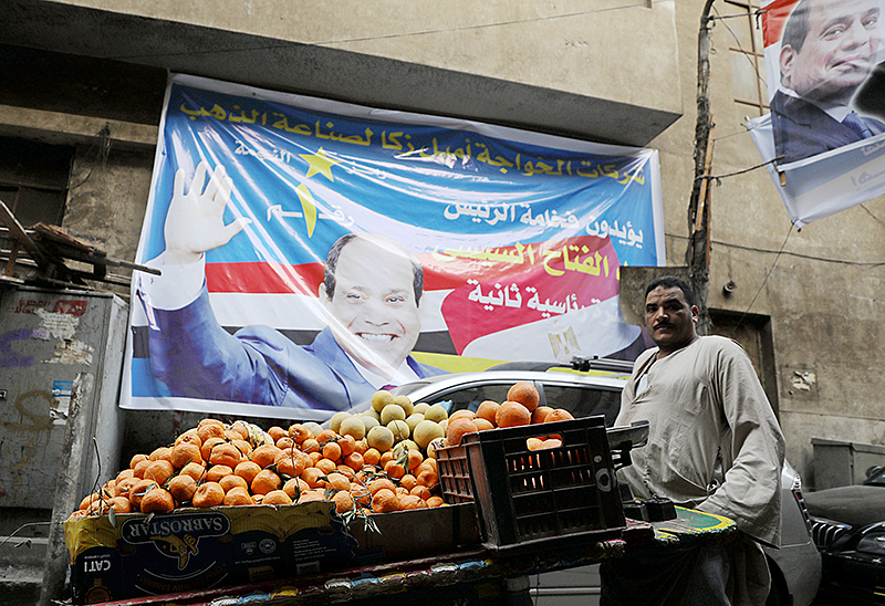 © Reuters//Mohamed Abd El Ghany Ein Marktverkäufer vor einem Wahlplakat