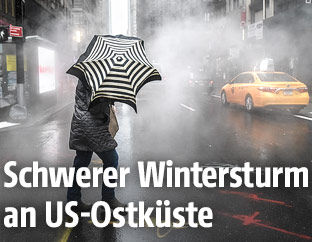 Mann kämpft sich mit Regenschirm durch die Straßen von New York