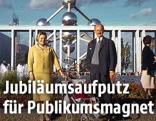 Ein Paar mit einem Kind im Kinderwagen im Jahr 1958 vor dem Atomium in Brüssel