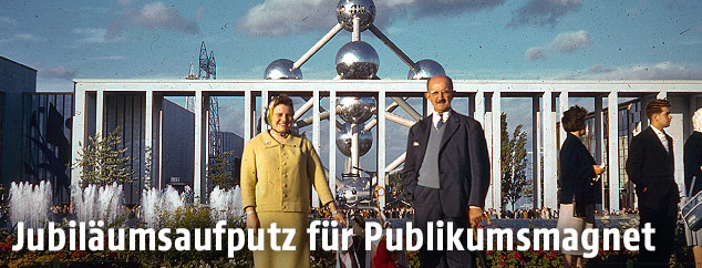 Ein Paar mit einem Kind im Kinderwagen im Jahr 1958 vor dem Atomium in Brüssel