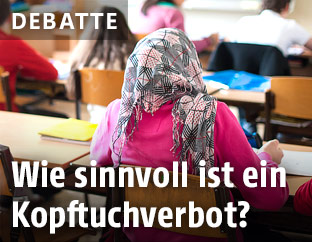 Mädchen mit Kopftuch sitzt in einer Schulklasse