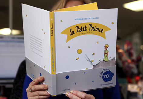 © APA/AFP/Patrick Kovarik Frau hält das Buch "Der kleine Prinz" von Antoine de Saint-Exupery