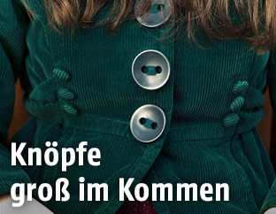 Frau trägt Mantel mit großen Knöpfen