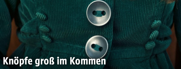 Frau trägt Mantel mit großen Knöpfen