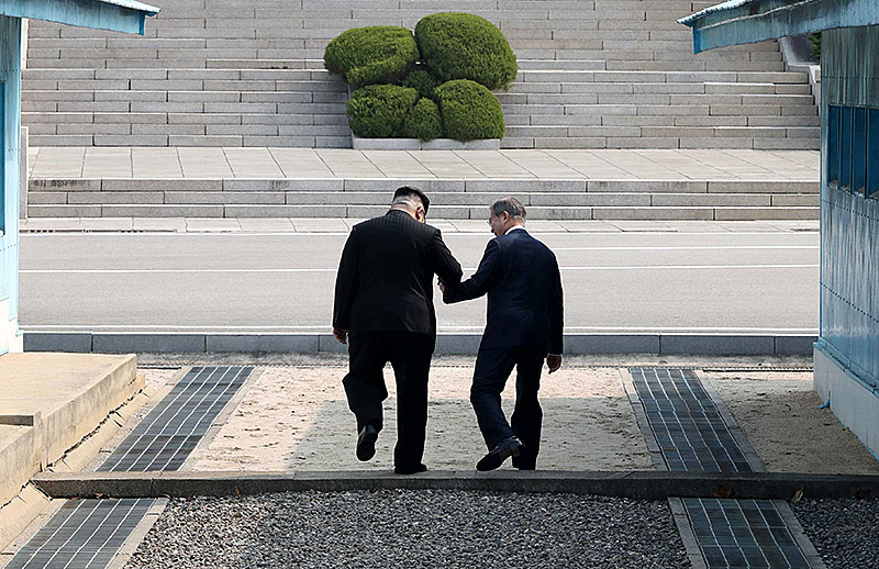 © Reuters/Korea Summit Press Nordkoreas Machthaber Kim Jong Un und Südkoreas Präsident Moon Jae übertreten gemeinsam die Demarkationslinie zwischen beiden Staaten