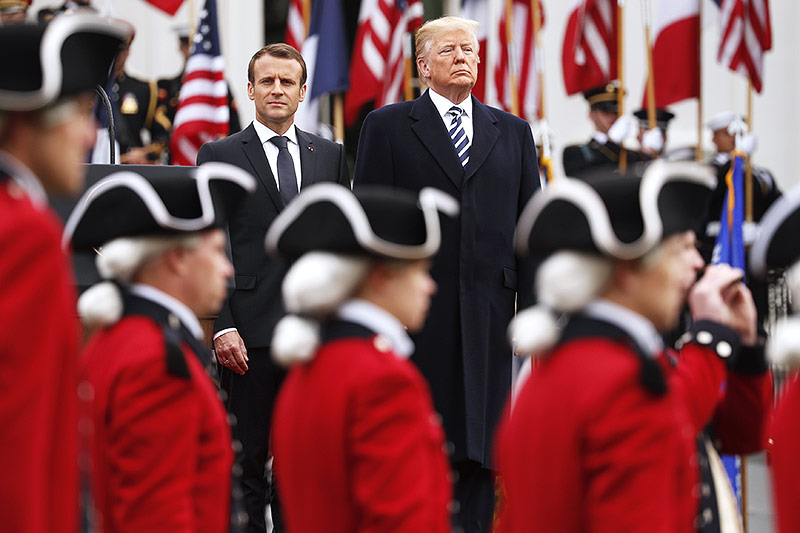 Der französische Staatschef Emmanuel Macron und US-Präsident Donald Trump die Hand betrachten eine Parade