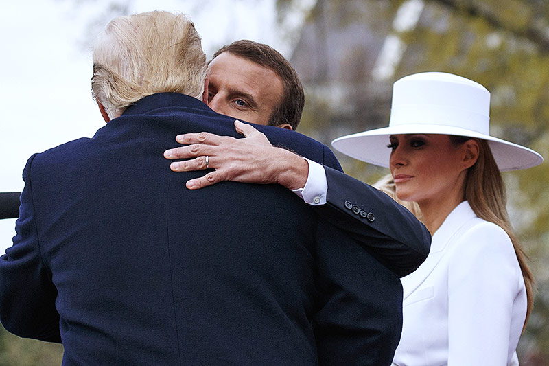 Der französische Staatschef Emmanuel Macron umarmt US-Präsident Donald Trump, daneben Melania Trump