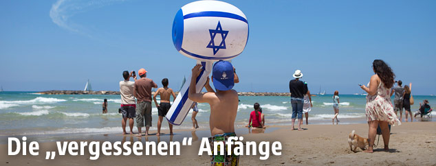 Kind am Strand hält einen Israel-Schwimmhammer