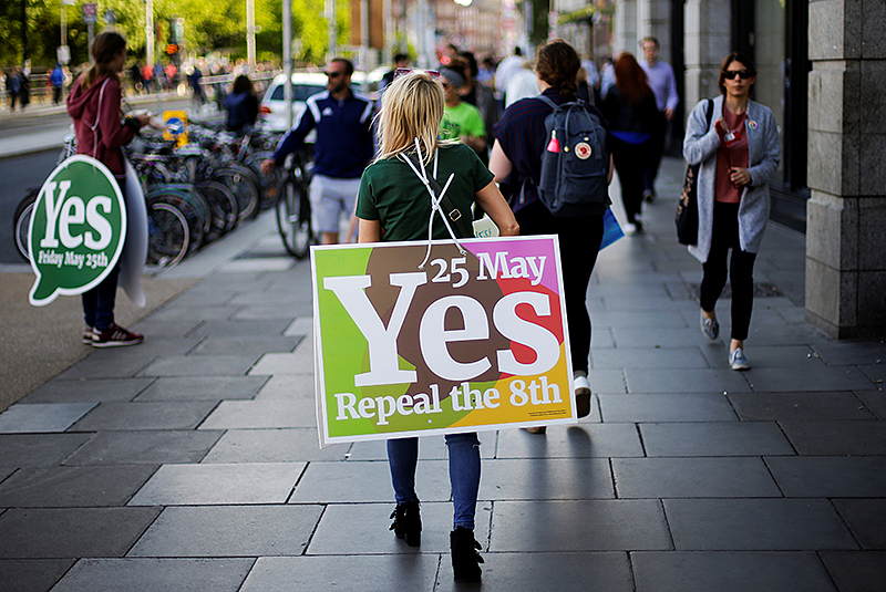 © Reuters/Max Rossi Eine Frau trägt ein Plakat zum Abtreibungsreferendum in Dublin (Irland)
