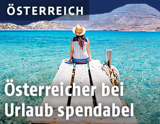 Eine Frau sitzt auf einem Steg am Strand