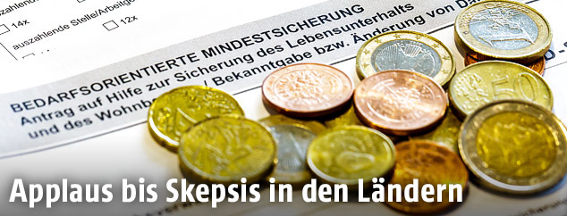 M&uuml;nzen liegen auf einem Antrag auf Mindestsicherung