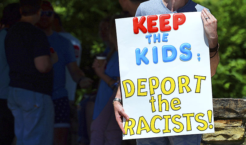 © APA/AP/Butch Comegys Mann mit einem Protestschild mit der Aufschrift "Keep the Kids; deport the racists"