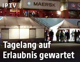 Rettungseinsatzkräfte vor dem angelegten Containerschiff