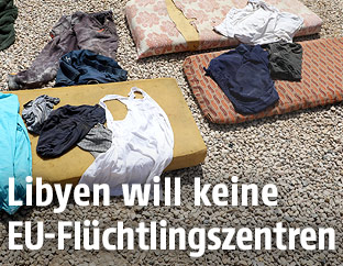 Schäbige Matratzen mit Kleidung darauf verstreut