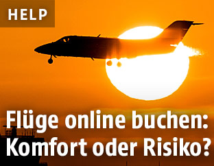 Ein Passagierflugzeug bei der Landung vor der untergehenden Sonne