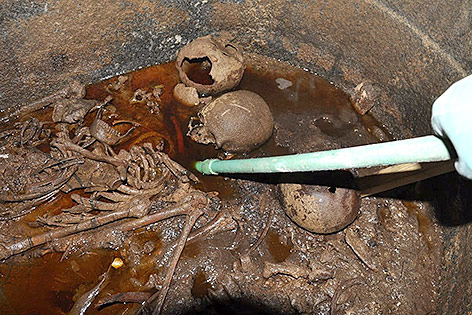 Menschliche Gebeine in geöffnetem Sarkophag