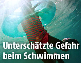 Unterwasseraufnahme eines schwimmenden Mädchens mit Schwimmreifen