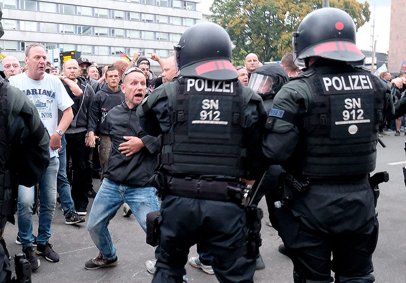 © APA/AFP/dpa/Sebastian Willnow Rechter Demonstrant schreit zwei Polizisten in Chemnitz an