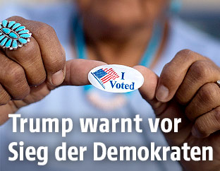Frau mit einem "I-voted-Aufkleber"